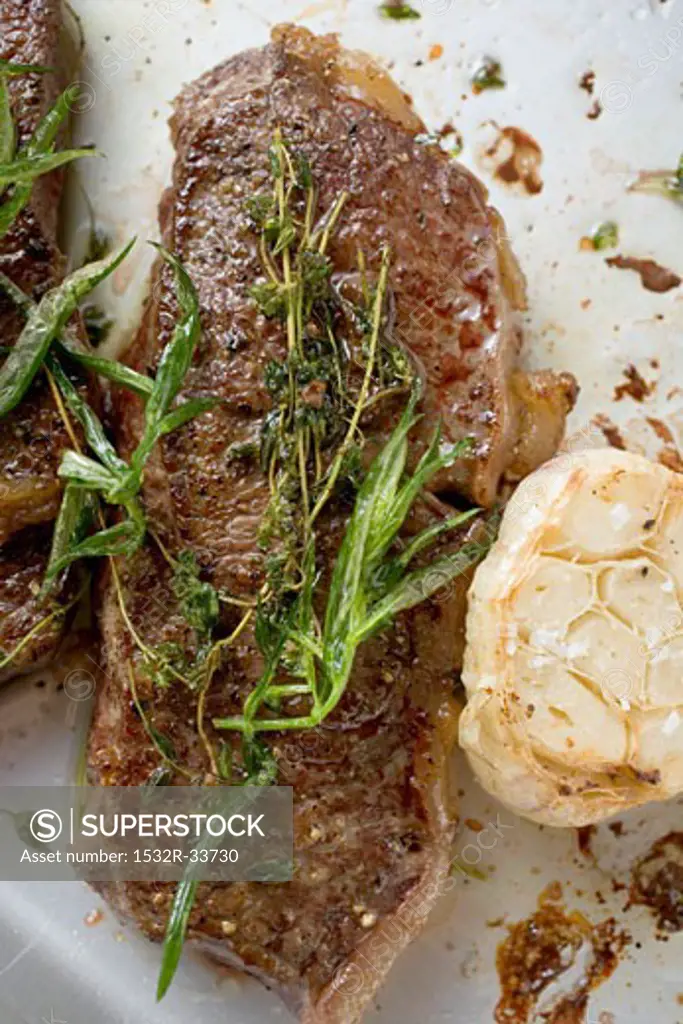 Beef steaks with herbs and garlic (overhead view)