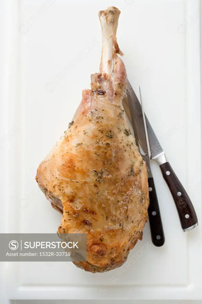 Roast turkey leg with carving knife and fork