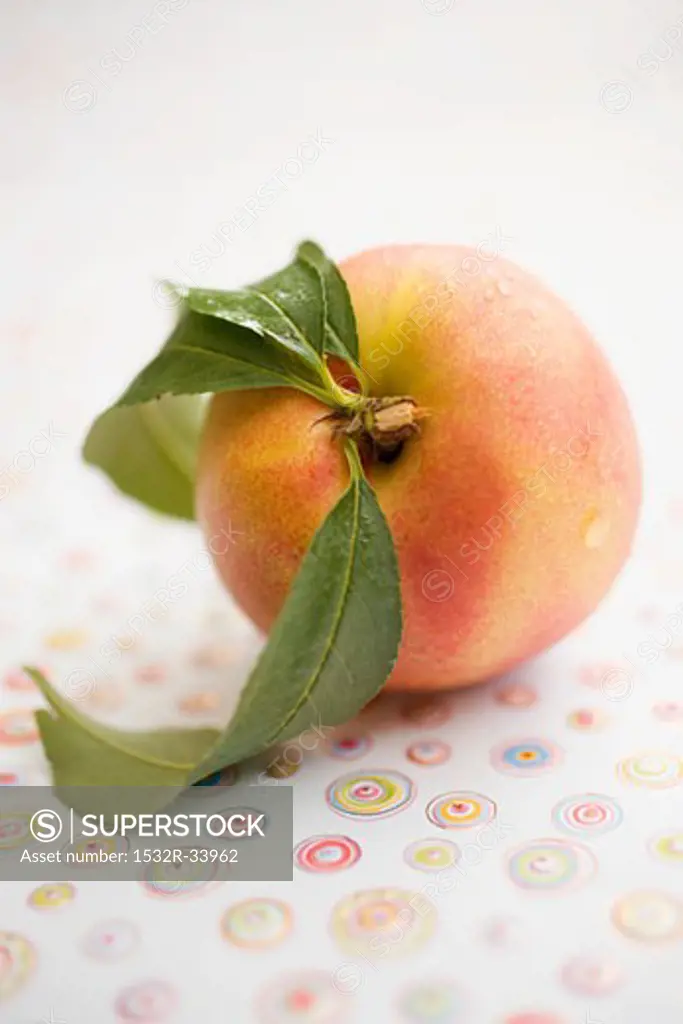 Nectarine with leaves and drops of water