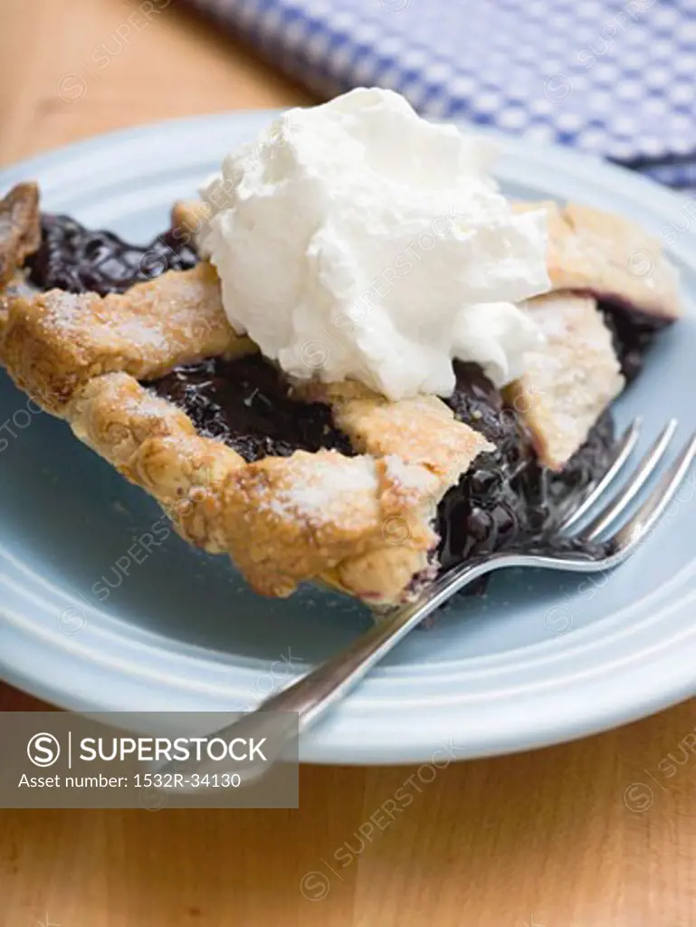 Piece of blueberry pie with cream