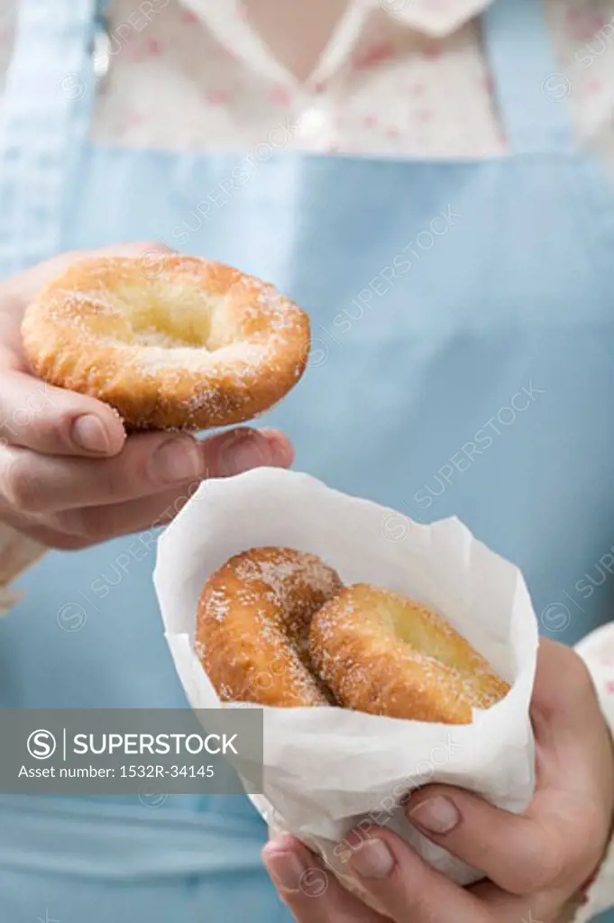 Woman holding Auszogene (Bavarian doughnuts)