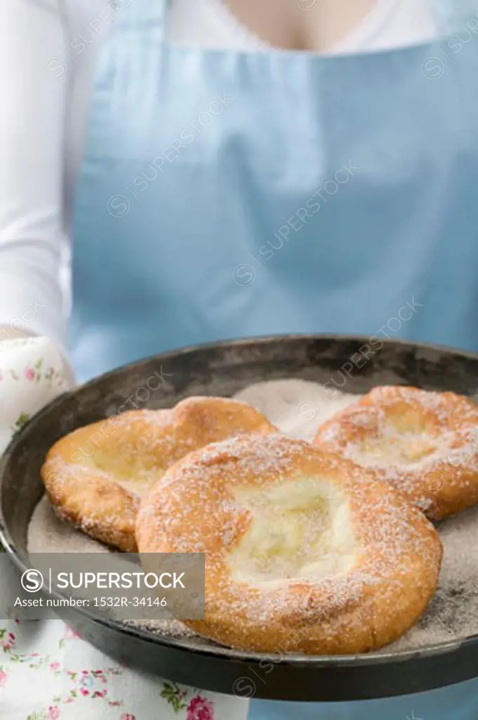 Woman holding Auszogene (Bavarian doughnuts)