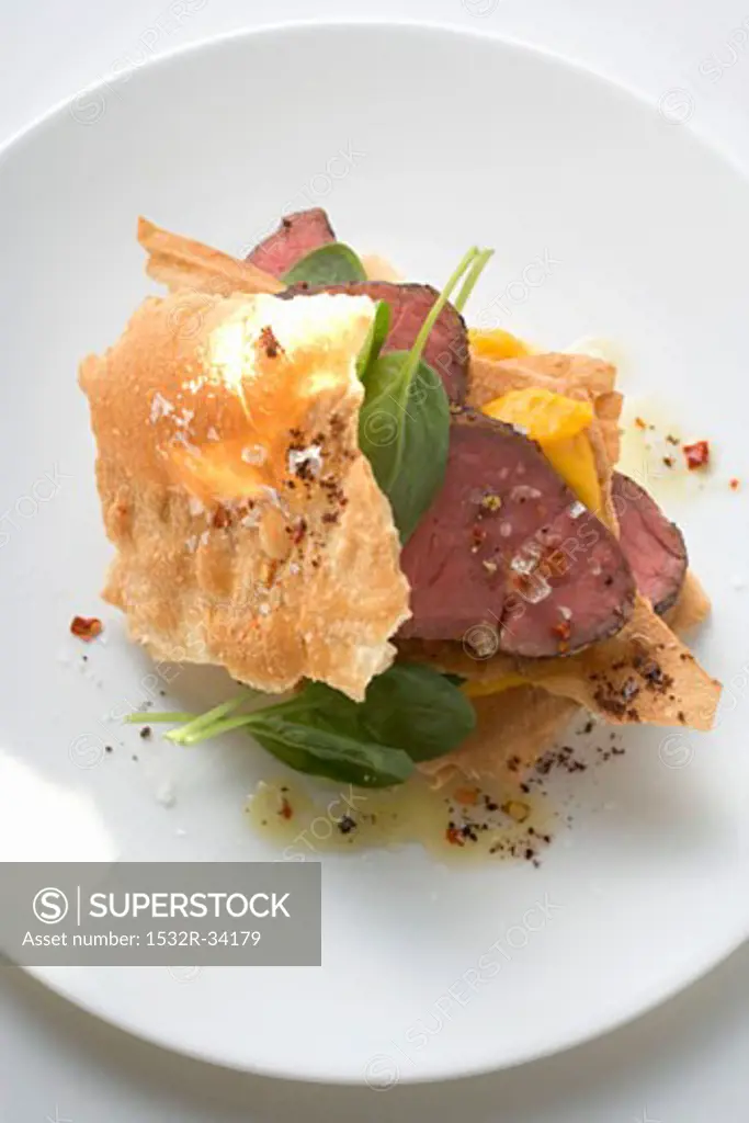 Beef fillet between sheets of pastry with basil and mango