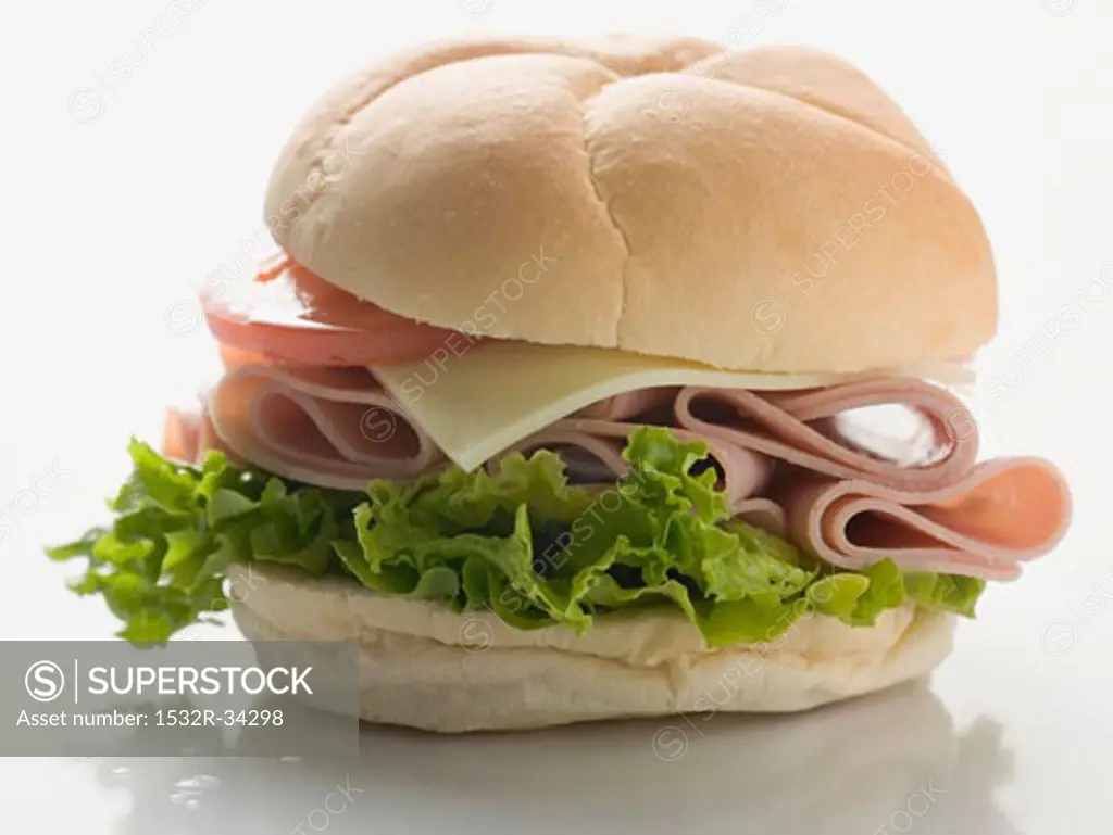Bread roll filled with ham, cheese, lettuce and tomato