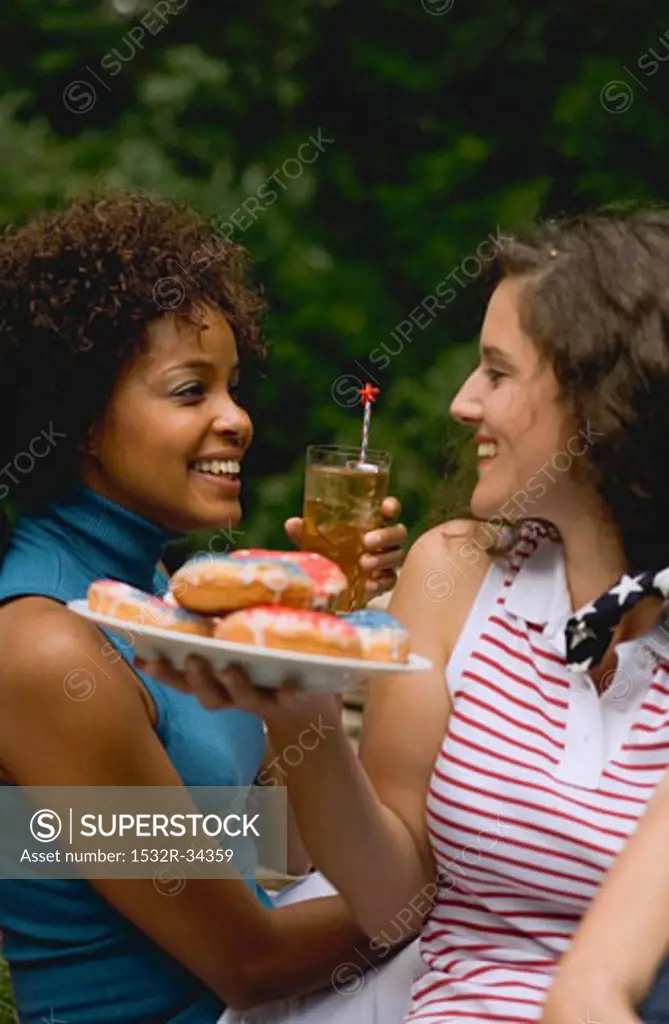 Two women with doughnuts & iced tea on the 4th of July (USA)