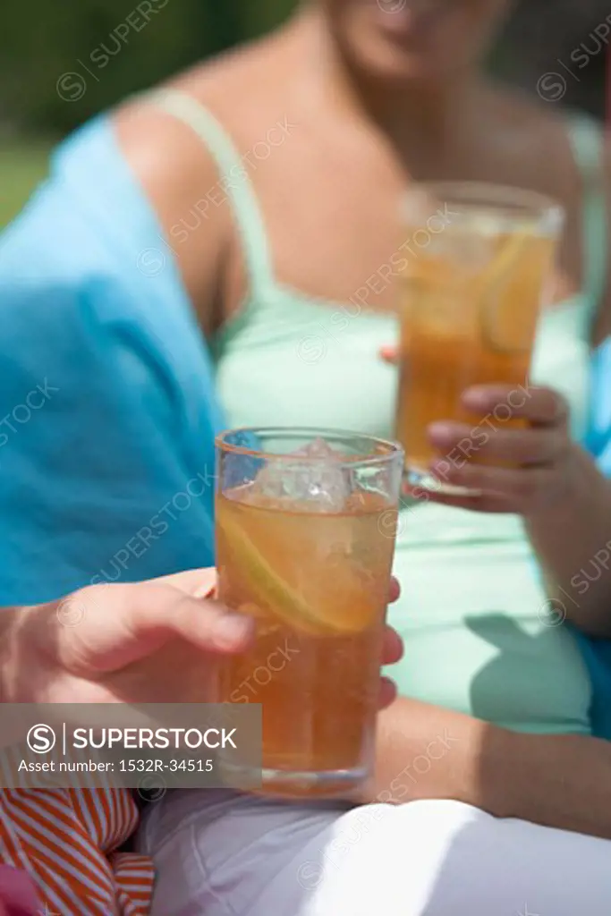 Two women holding glasses of iced tea