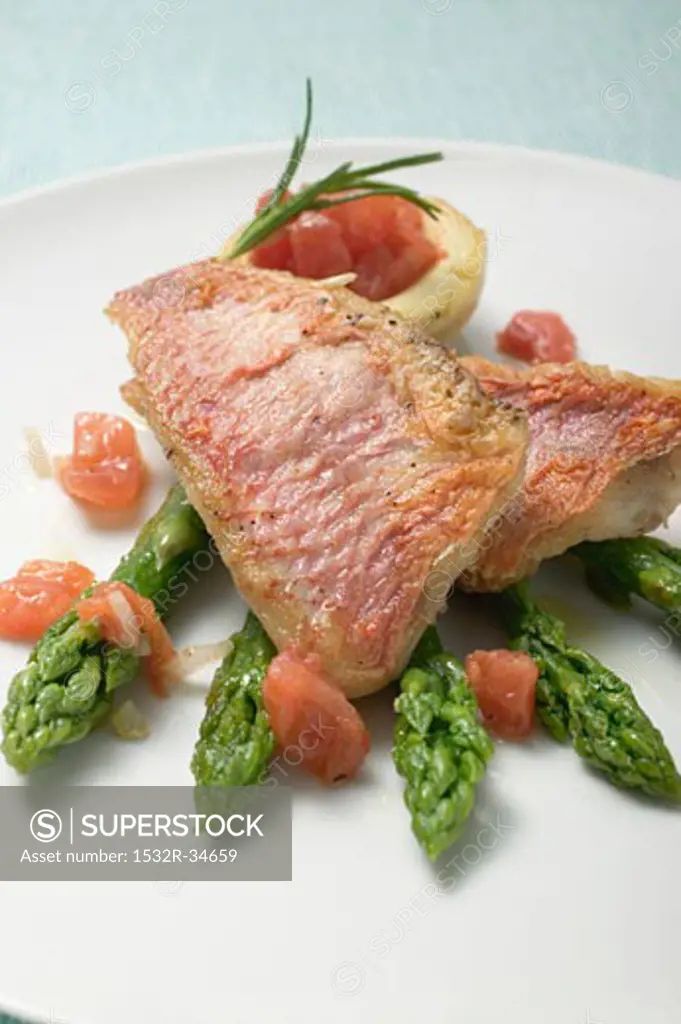 Fried red mullet fillets with asparagus and tomatoes