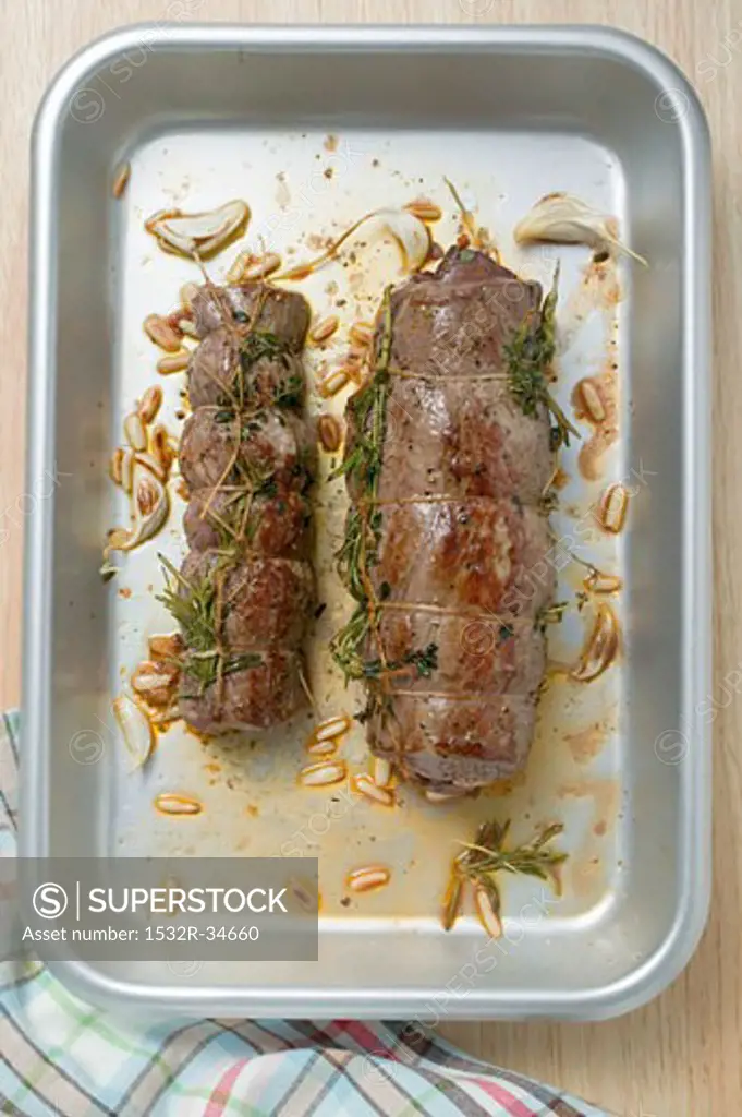 Beef roulades with herbs and pine nuts in roasting tin