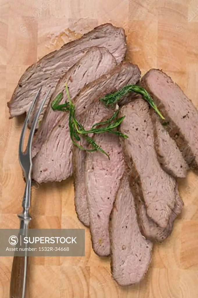 Slices of lamb on wooden background