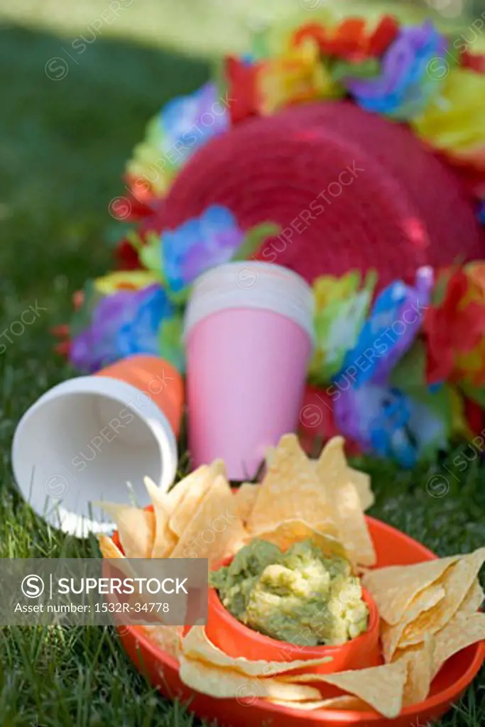 Guacamole with tortilla chips, paper cups, coloured garlands