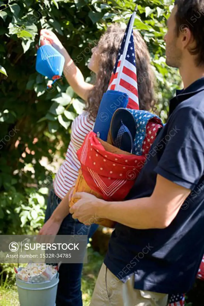 Couple with equipment for a 4th of July picnic (USA)