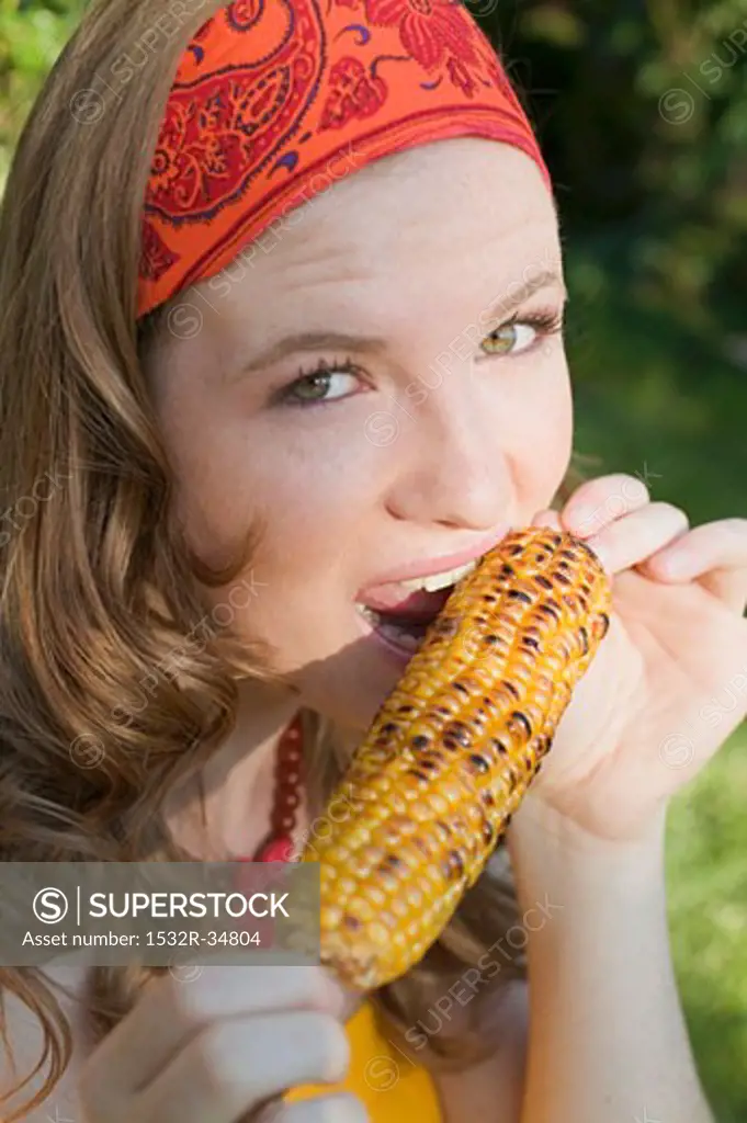 Woman eating grilled corn on the cob