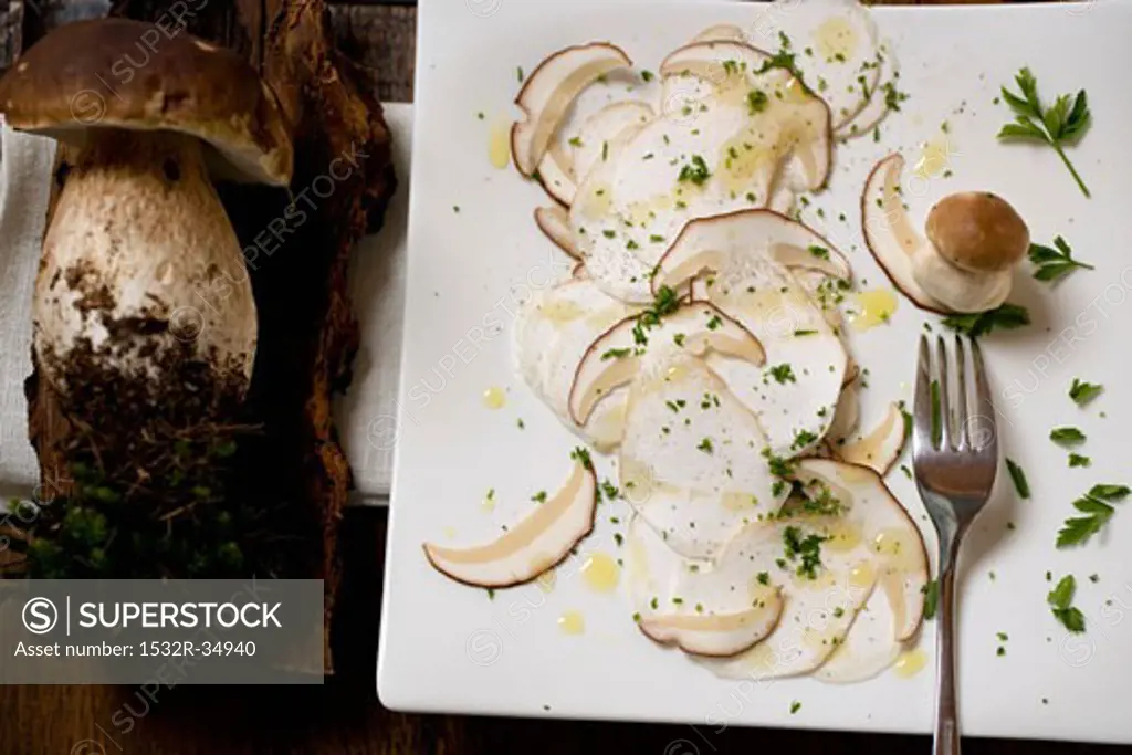 Cep carpaccio on chopping board and whole ceps