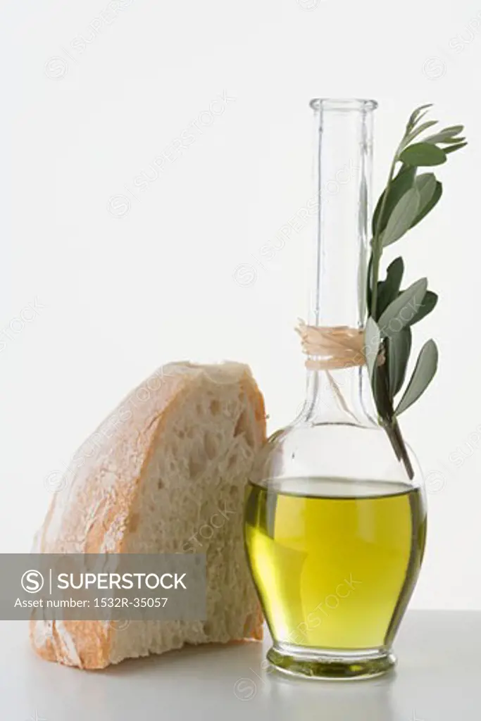 Olive oil in carafe, piece of white bread beside it