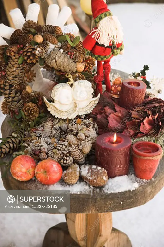 Christmas decorations on wooden table in snowy garden