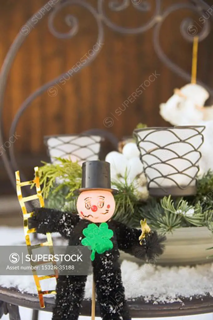 Chimney sweep on snow-covered garden table