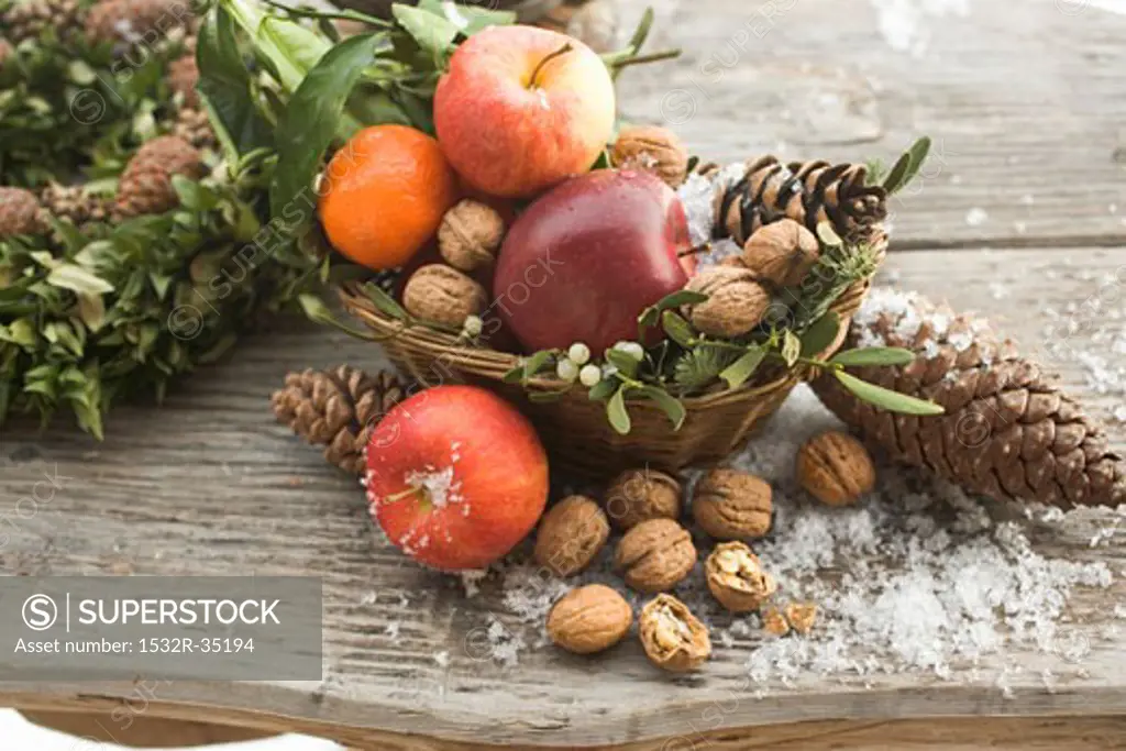 Rustic Christmas decoration with apples, nuts and cones