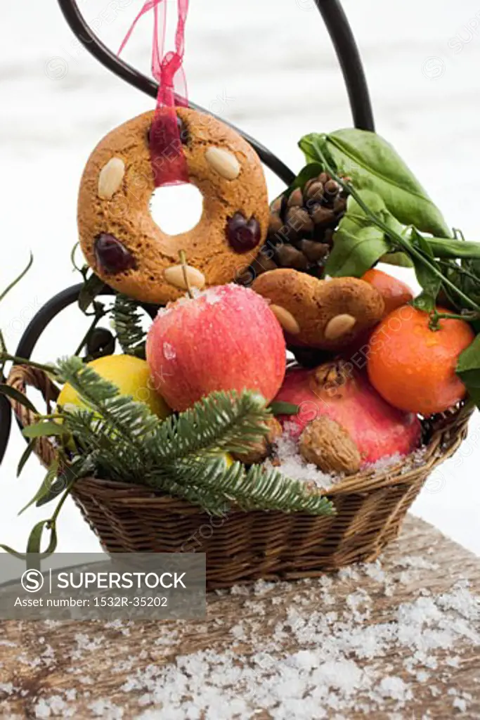 Gingerbread, fruit, nuts and cones in a basket