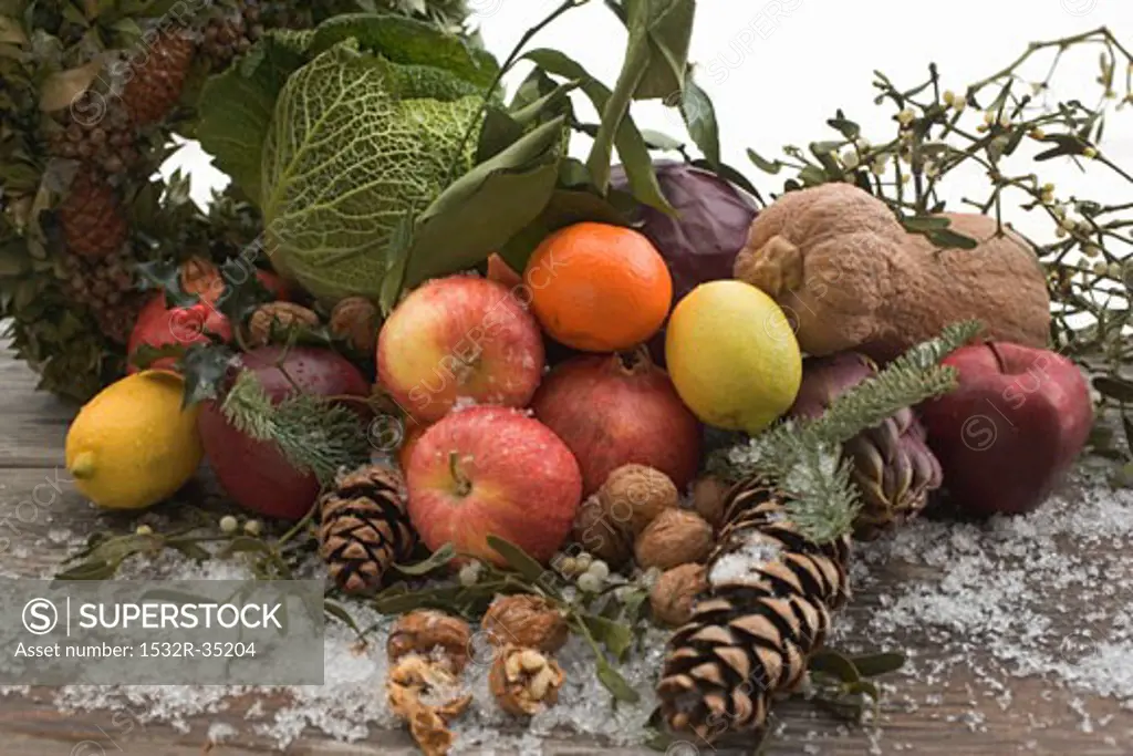 Fruit, vegetables, nuts, fir cones on wooden table out of doors