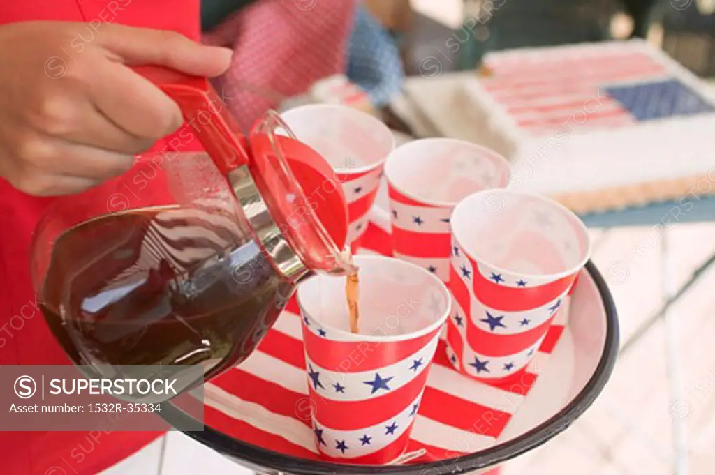 Woman pouring coffee into a paper cup (4th of July, USA)