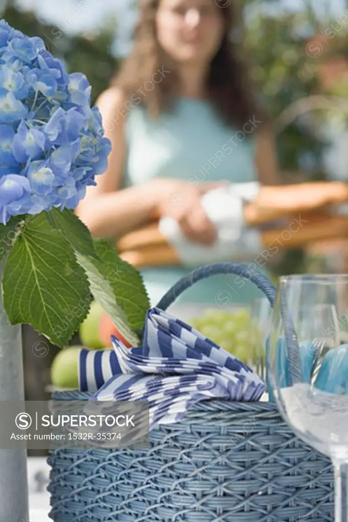 Table laid for a summer party, woman in background