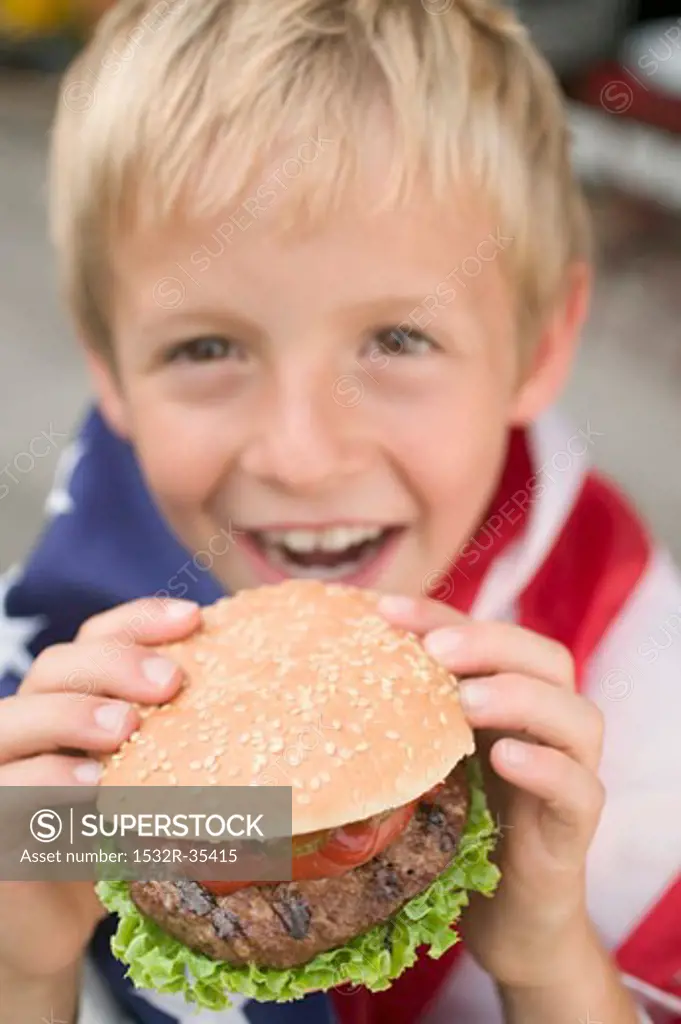 Small boy holding hamburger (4th of July, USA)