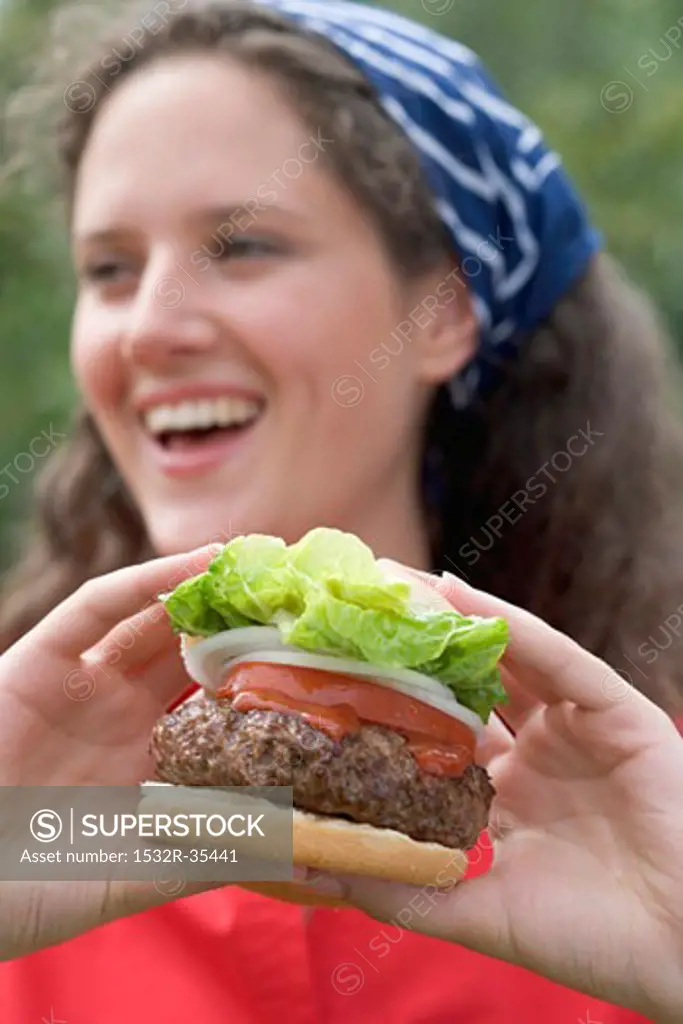 Woman holding large hamburger