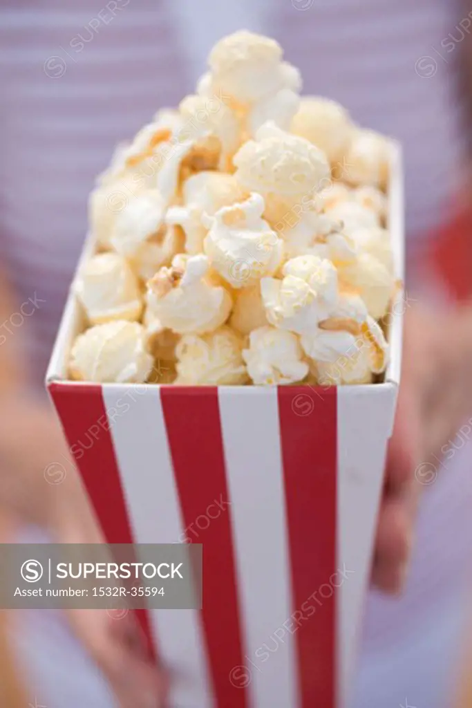 Woman holding popcorn in striped box (4th of July, USA)