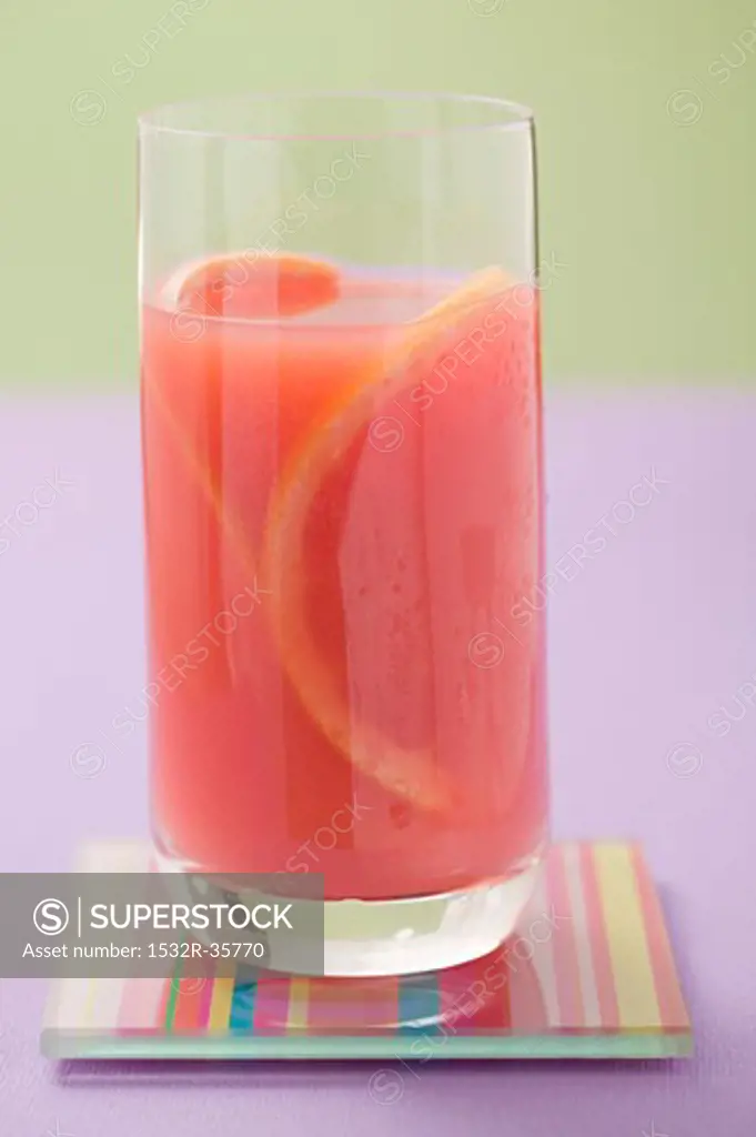 Glass of pink grapefruit juice with slices of grapefruit