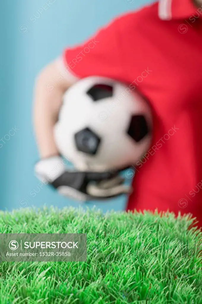 Footballer behind artificial turf