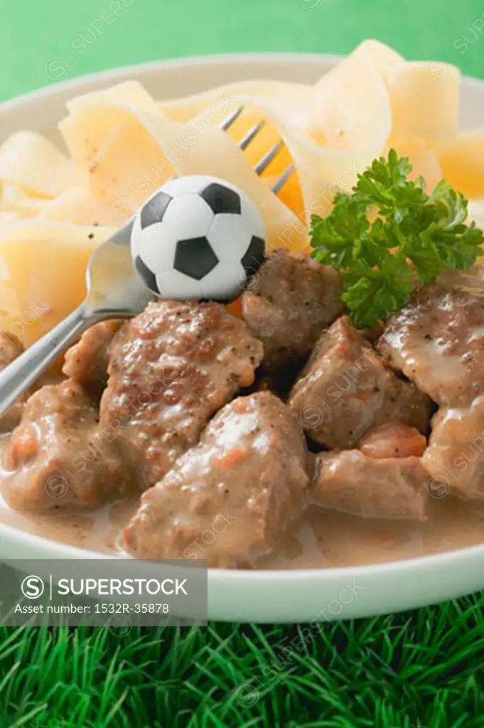 Zürcher Geschnetzeltes (veal dish) with pasta, football & fork