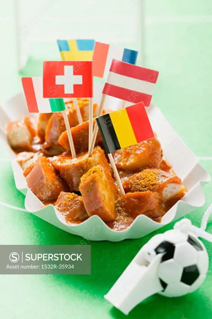 Currywurst with various flags in paper dish