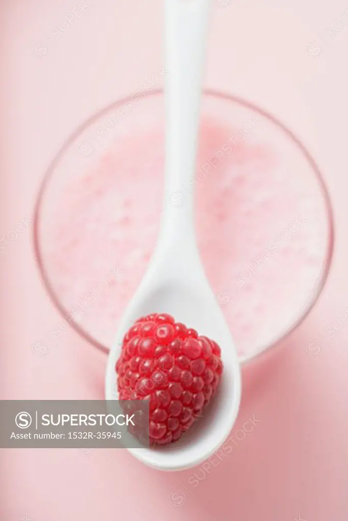 Raspberry shake with spoon & fresh raspberry (overhead view)