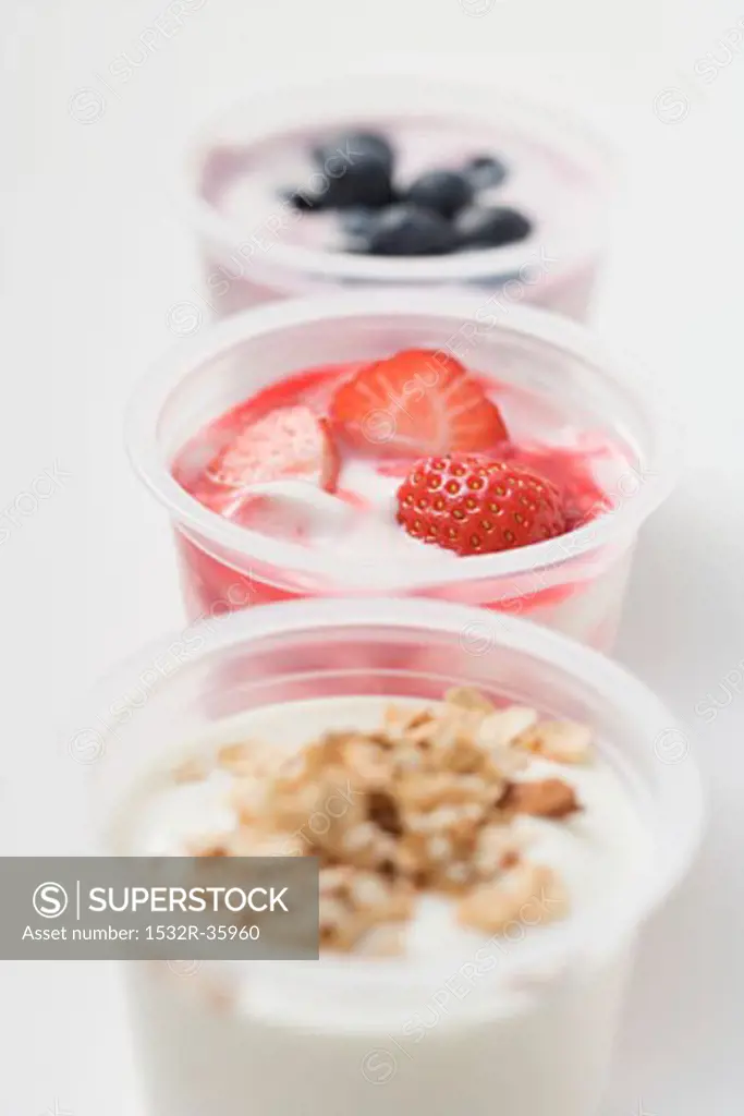 Three yoghurts with berries and cereal