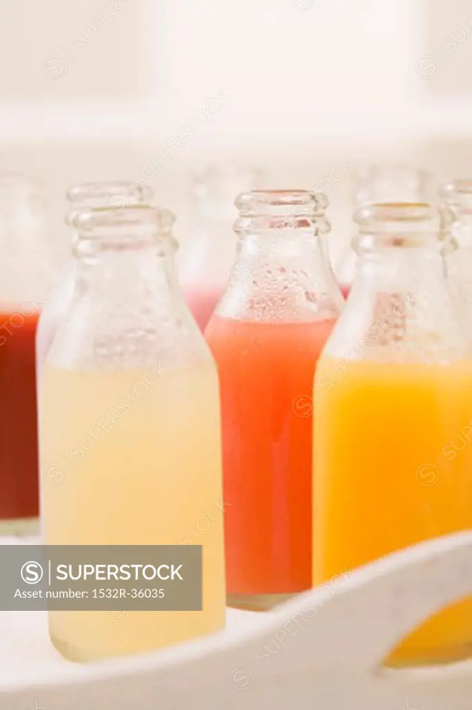 Various different juices in small bottles on tray