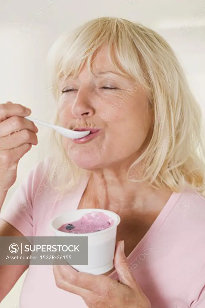 Woman eating blueberry yoghurt