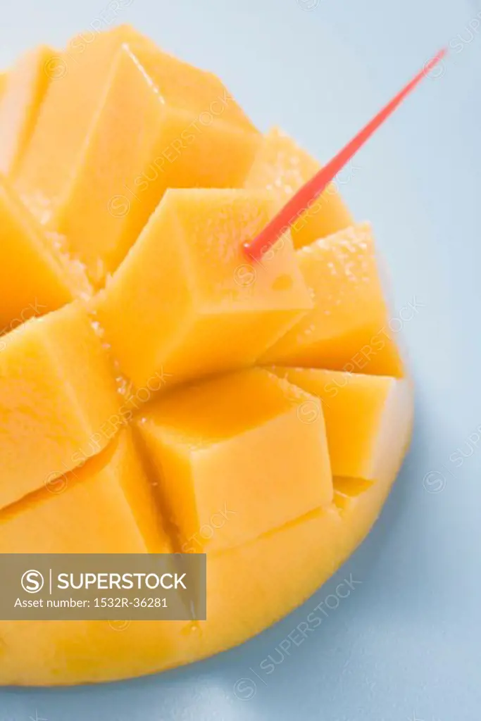 Diced mango still attached to the skin with cocktail stick
