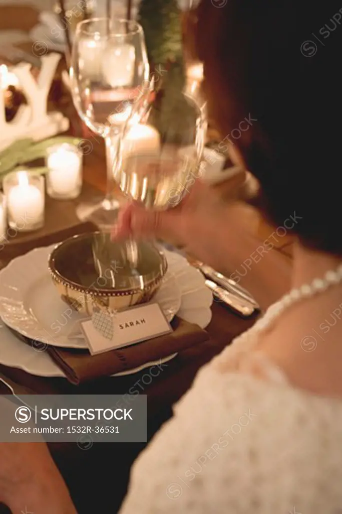 Woman drinking white wine at Christmas meal