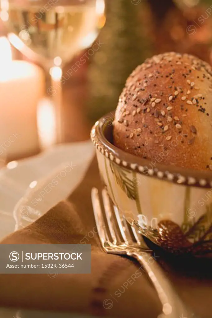 Place-setting with sesame roll on Christmas table (close-up)
