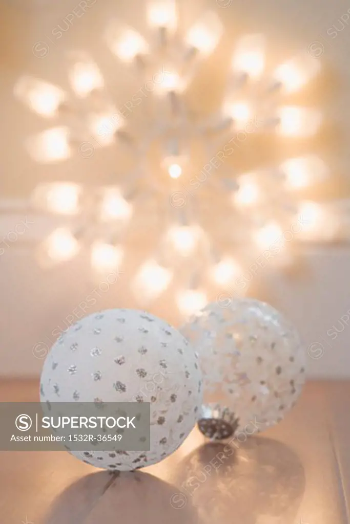 Two different Christmas tree baubles and illuminated star