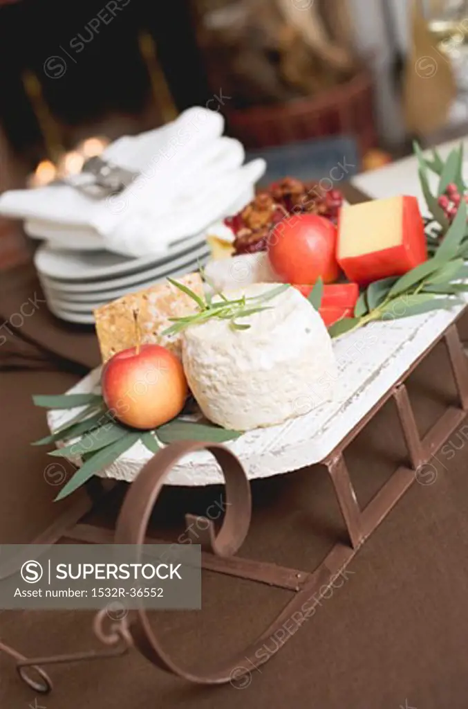 Small sleigh filled with cheese and apples for Christmas