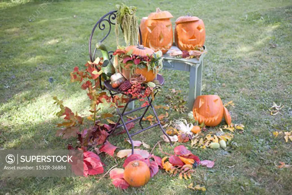 Autumnal garden decoration with pumpkins, flowers & leaves