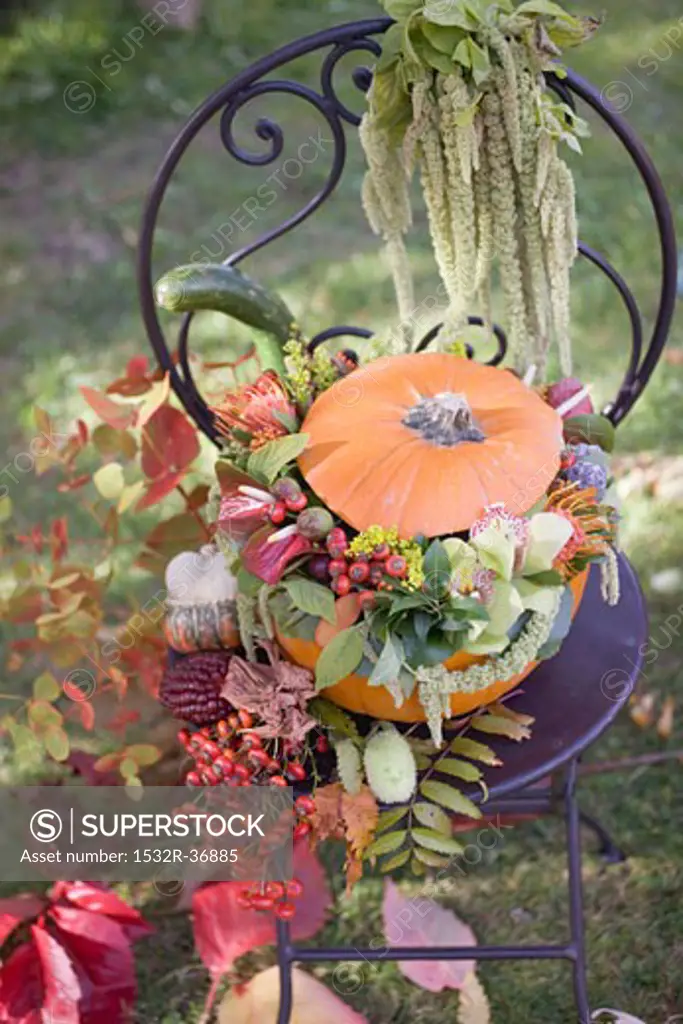 Pumpkin decorated with flowers on garden chair
