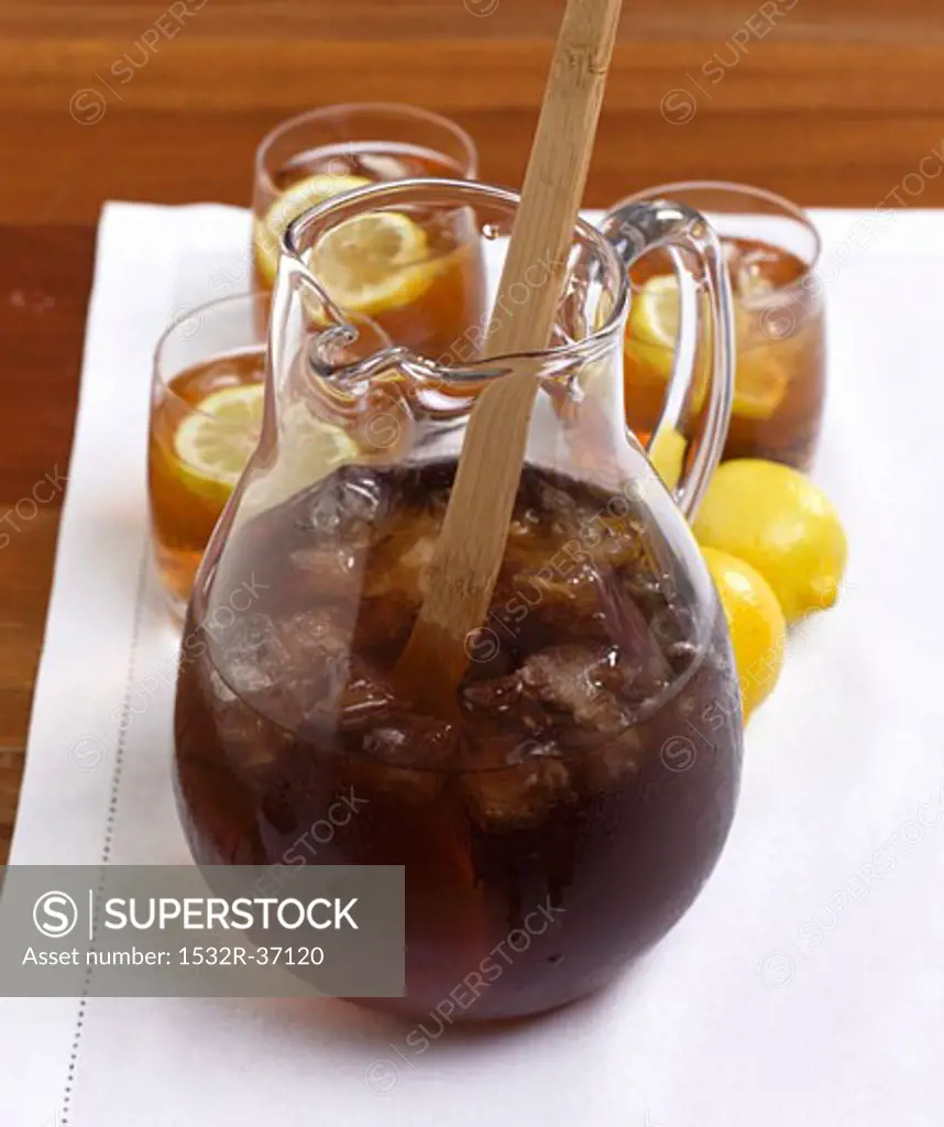 A Pitcher of Iced Tea with Wooden Spoon, Glasses and Lemons