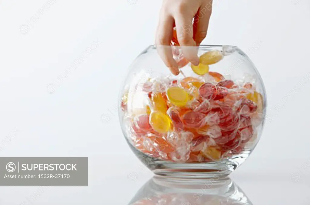 Child's hand reaching into a sweet jar