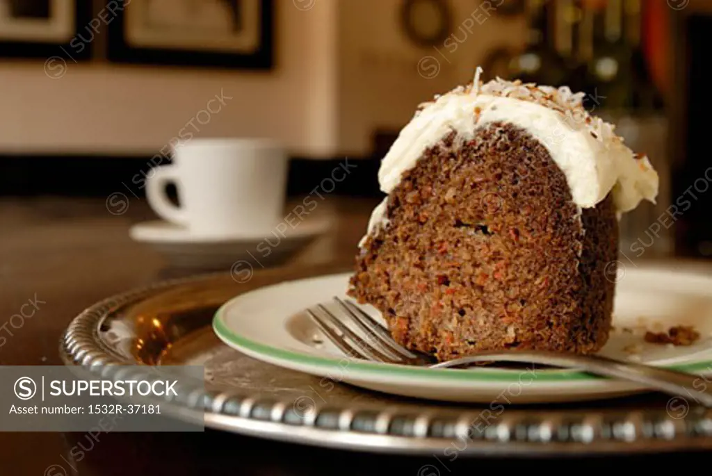 A piece of carrot and nut cake with cream topping