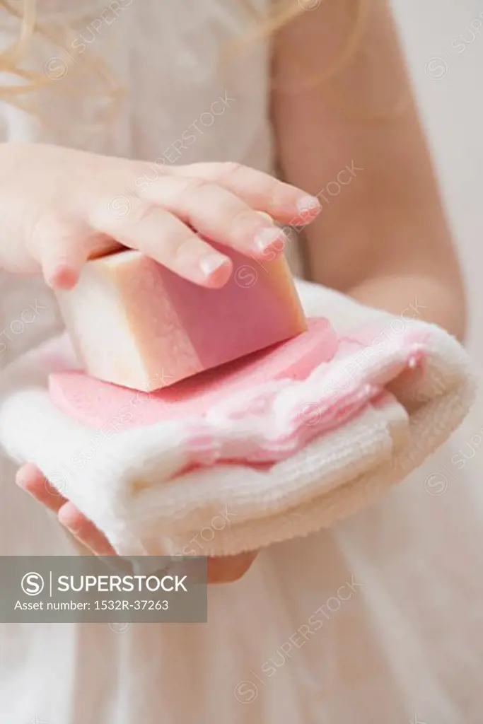 Girl holding soap and towel
