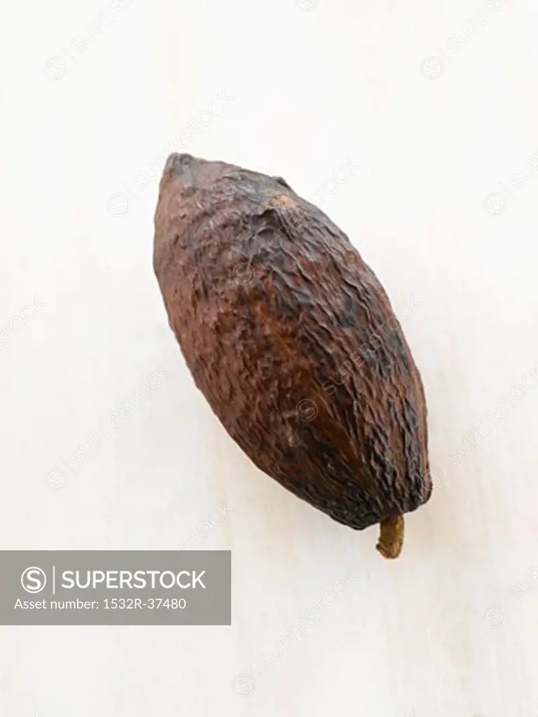 A cacao fruit on white wooden surface