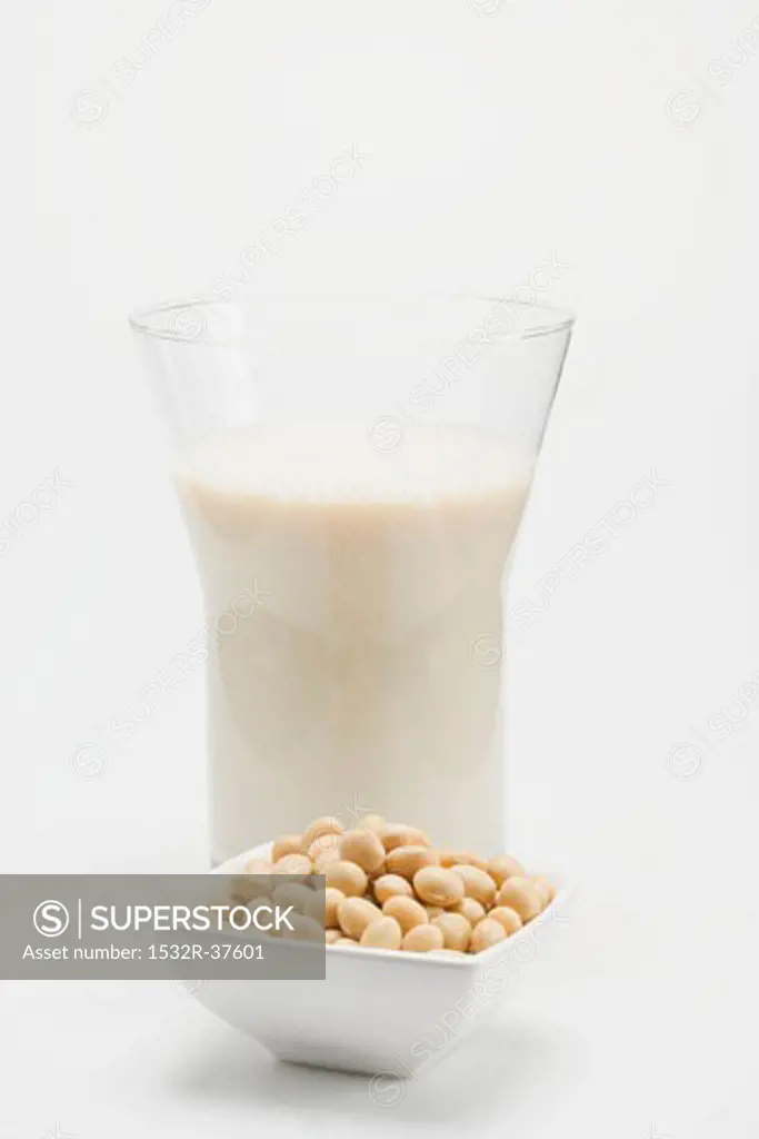 A glass of soya milk, small dish of soya beans in front
