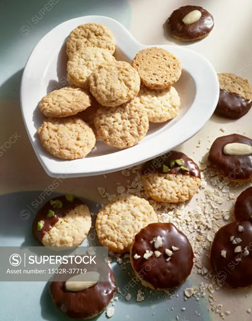 Chocolate-dipped & -coated oat biscuits on heart-shaped plate